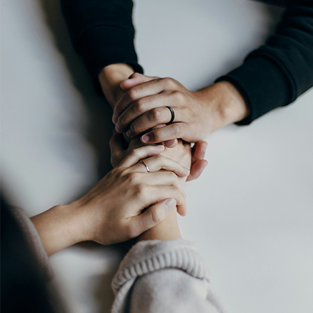 Interlocking hands of two people.